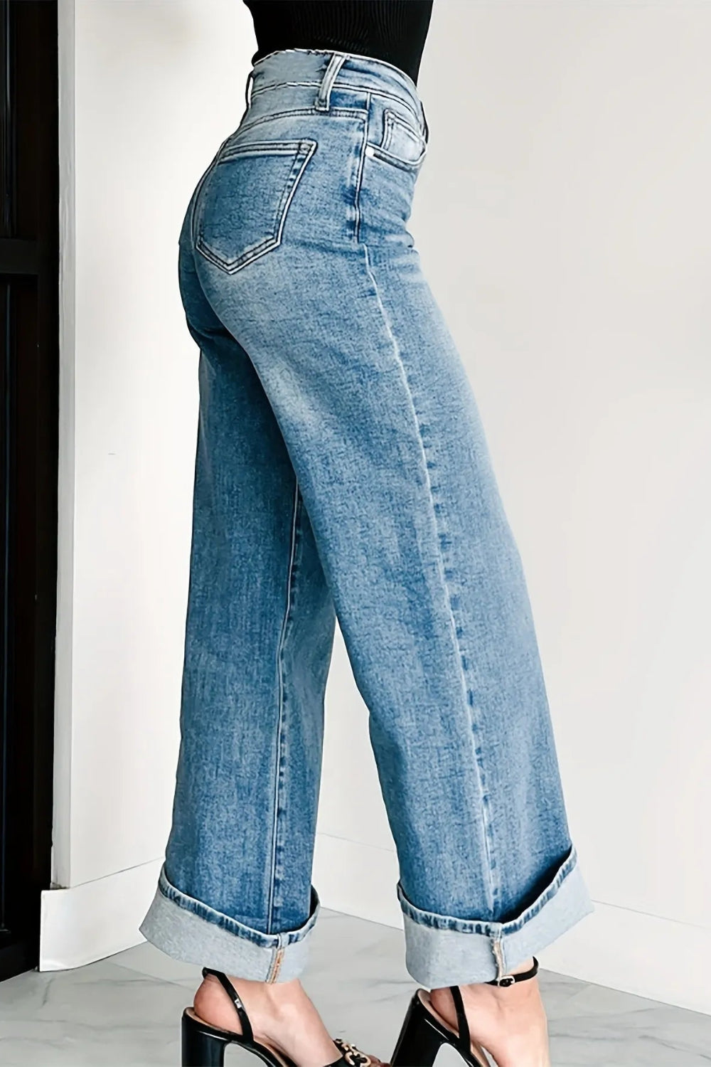 Jeans, high-waist, light wash, wide leg, pocketed, belt loops, button/zipper closure, relaxed fit, slightly stretchy, side view