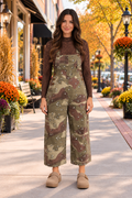 Front view of the Blending In Overalls in green and brown camouflage with adjustable straps, bib pocket, side buttons, and cropped wide legs.
