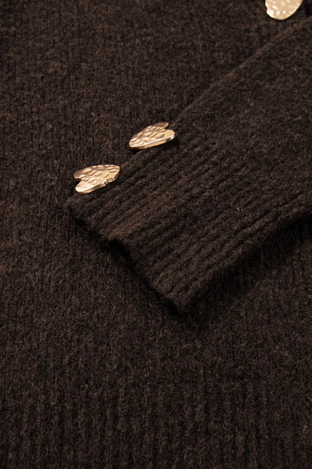 cardigan, chocolate color, long sleeve, v-neck, metal heart shaped button on front and cuffs, ribbed, medium length, slightly stretchy, close up cuff view