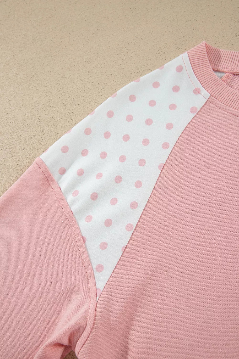 Social Club Pant Set with a light pink cropped sweatshirt, polka-dot shoulder panels, and matching wide-leg drawstring pants close up view.