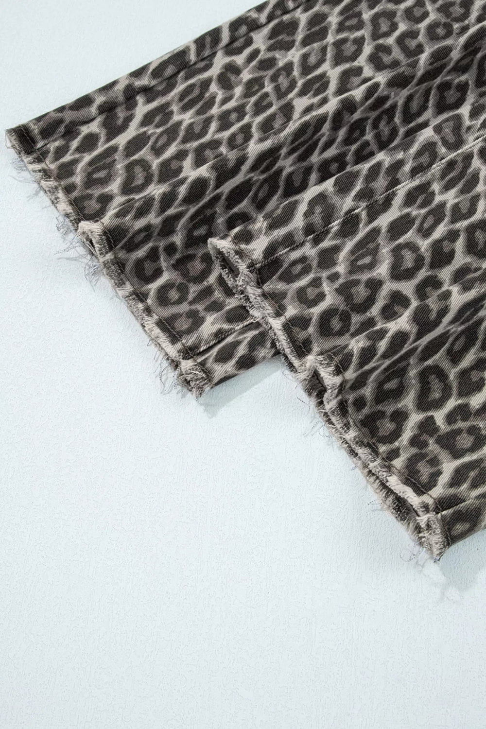 Jeans, leopard print, mid-rise, straight leg, elastic waist, belt loops, pocketed, button/zipper closure, frayed hem, some stretch, hem close up
