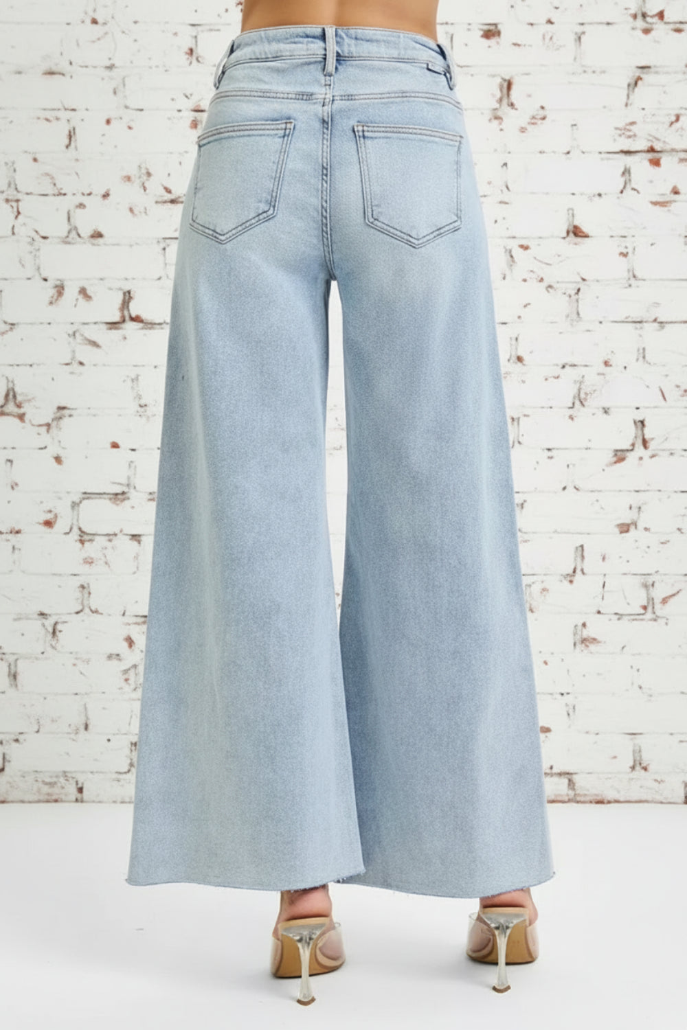 Risen Jeans, full-size, high-rise, wide leg, palazzo style, light wash, raw hem, button/zipper closure, belt loops, pocketed, slightly stretchy, back view
