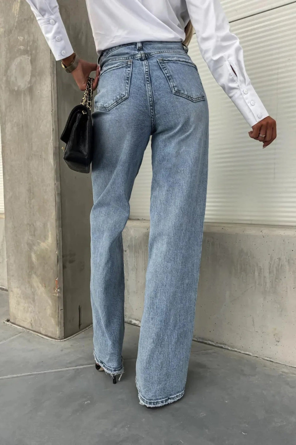 Jeans, high-waist, light wash, raw hem and pockets, straight leg, pocketed, belt loops, button/zipper closure, relaxed fit, slightly stretchy, back view