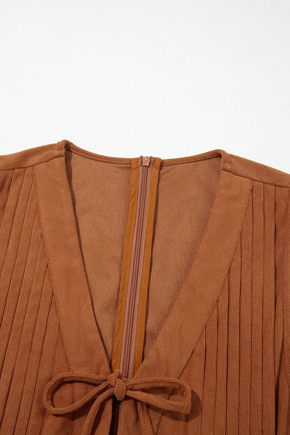 Front view of the As You Were Romper in rust brown corduroy with a tie V-neck, back zipper, pleated details, and side pockets.