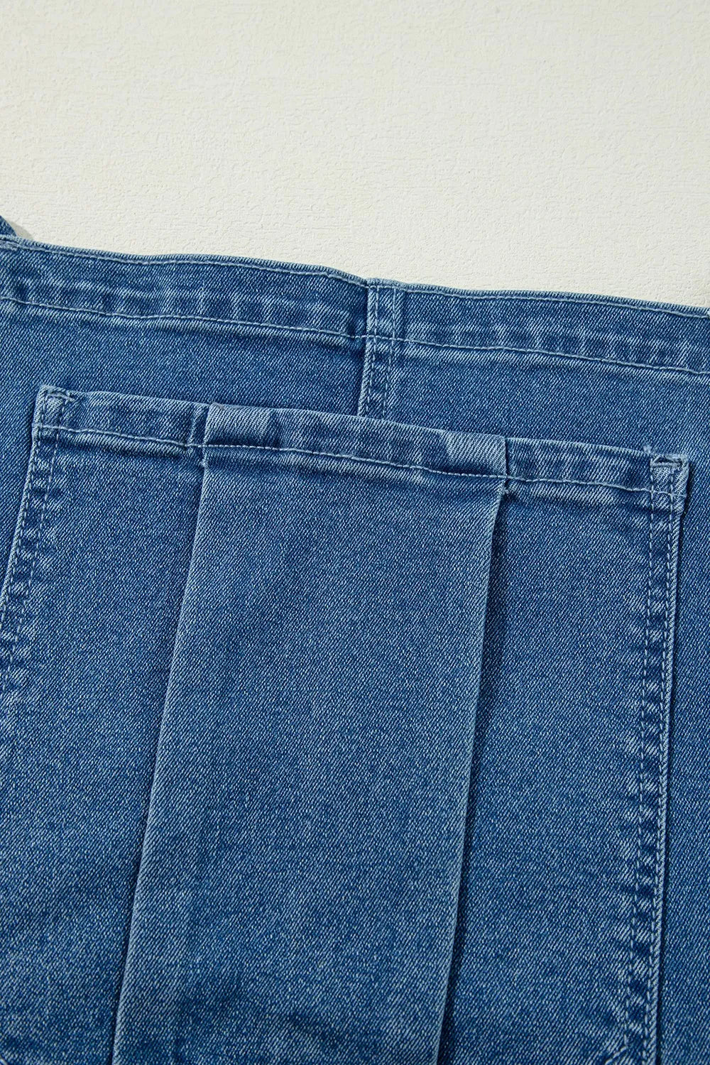 Denim overalls, adjustable tie straps, square neck, backless, wide leg, pocketed, button sides, no stretch close up view