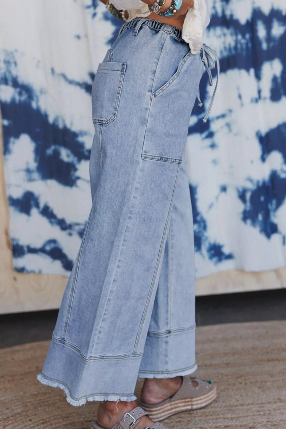 Pants, denim, high-rise, elastic waist, drawstring, belt loops, pocketed front and back, raw/frayed hem, wide leg, slightly stretchy, side view