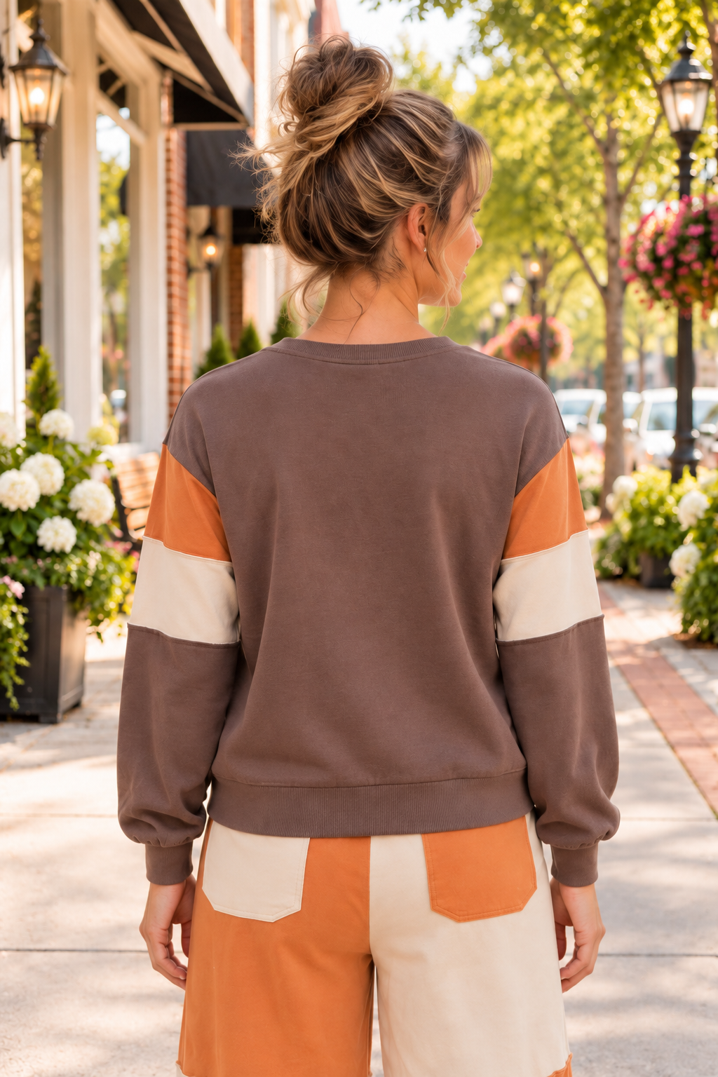 A Change Of Pace Sweatshirt in mocha brown with rust-orange and cream color-block sleeves, shown from the back.
