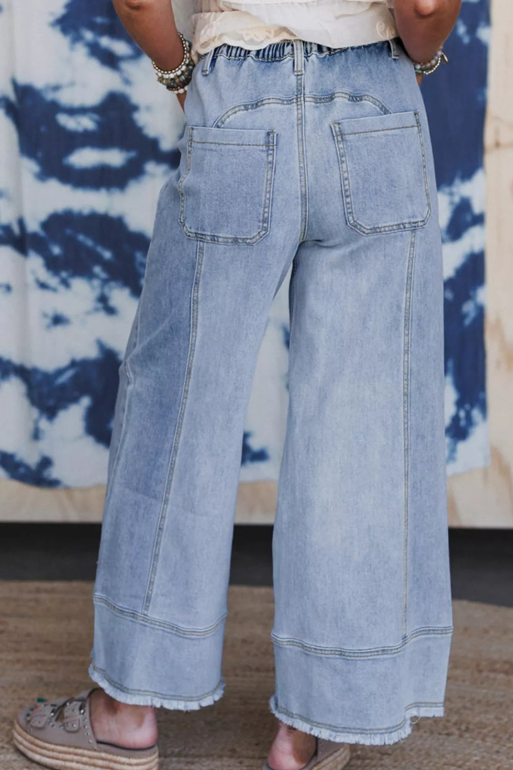 Pants, denim, high-rise, elastic waist, drawstring, belt loops, pocketed front and back, raw/frayed hem, wide leg, slightly stretchy, back view