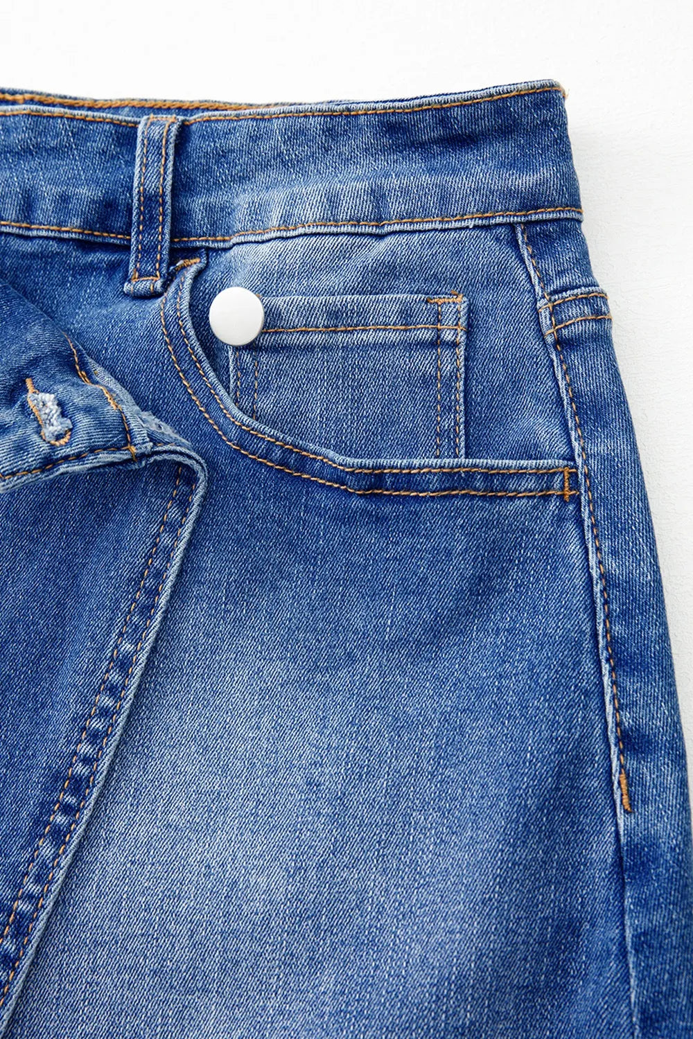Shop The  Overlap Mini Skirt featuring a medium-blue wash, asymmetrical wrap-style front, curved seam detailing, and flattering A-line fit.