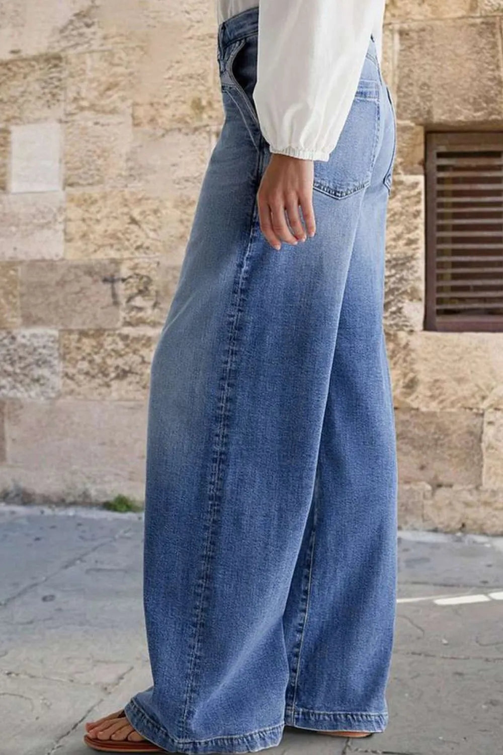Jeans, high-waist, vintage wash, wide leg, front embroidered pockets, raw hem, back pockets, button/zipper closure, belt loops, slightly stretchy, side view