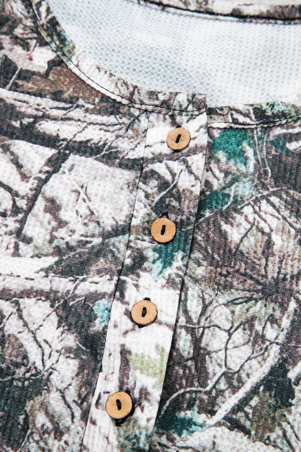 The Renegade Short Set in woodland camouflage with a long-sleeve button-front top and drawstring shorts with pockets close up view.