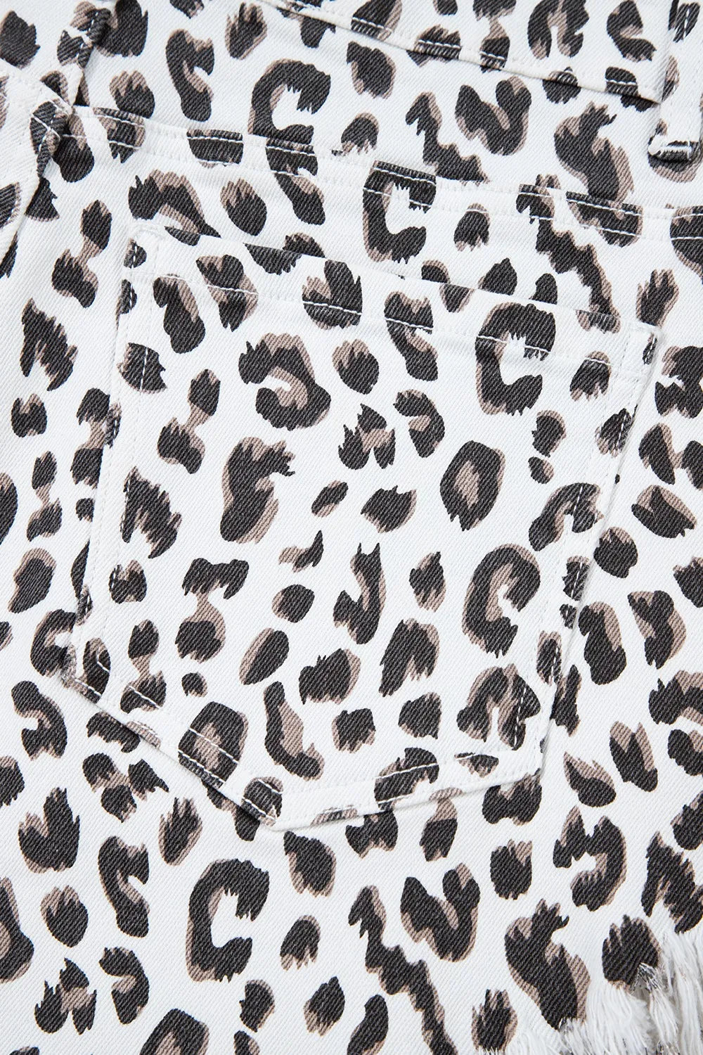 Denim shorts, Leopard print, White, Frayed hem, High waist, Functioning pockets, Belt loops, Zipper and button closure, Medium-high elasticity Close up view
