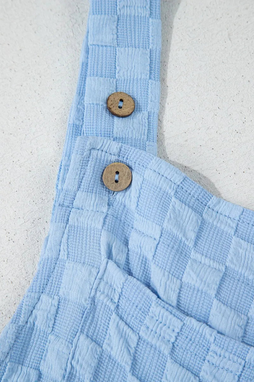 Overalls, square neck, wide leg, checkered, pocketed, buttoned straps, high waist, pleated, some stretch, close up view