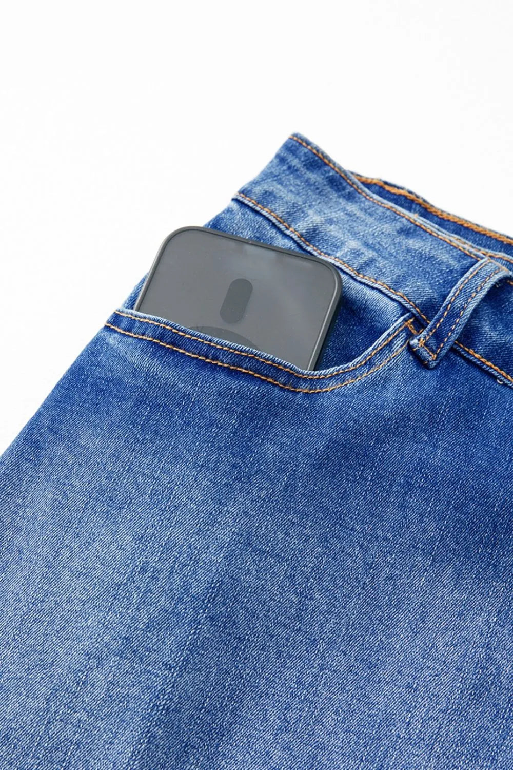 Shop The  Overlap Mini Skirt featuring a medium-blue wash, asymmetrical wrap-style front, curved seam detailing, and flattering A-line fit.