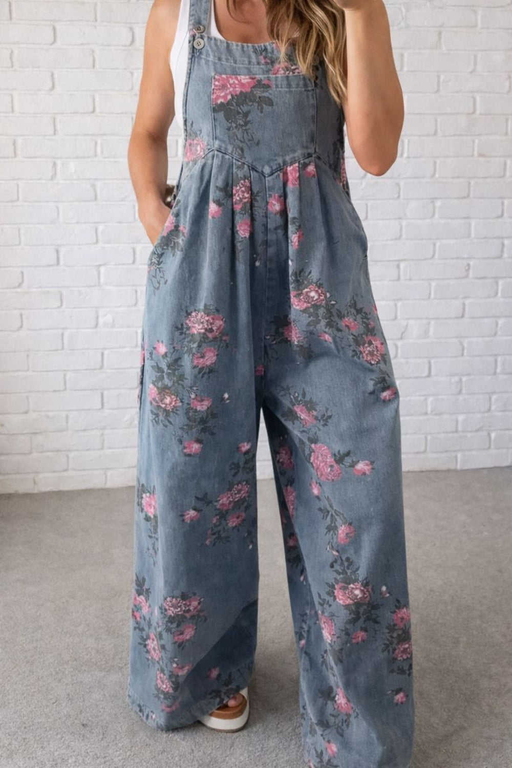 Overalls, floral print, wide leg, front bib pocket, front pockets, pleated, button straps, single back pocket, side button closure sit high, medium wash, slightly stretchy, front view close up