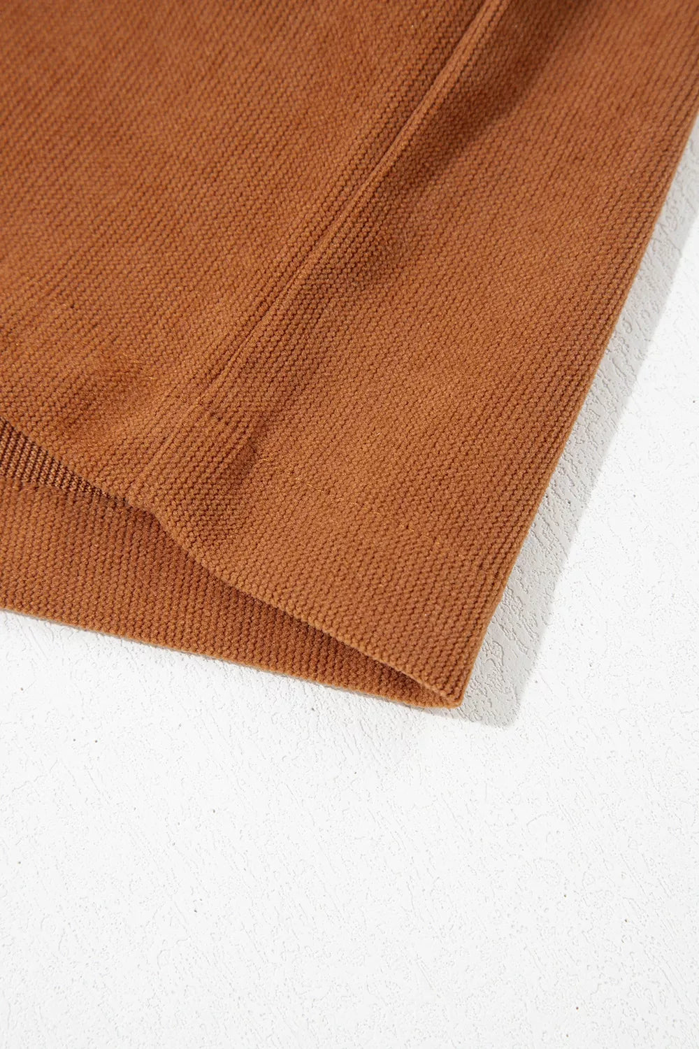 Front view of the As You Were Romper in rust brown corduroy with a tie V-neck, back zipper, pleated details, and side pockets.