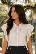* Ruffle neck
* Ruffle sleeve
* Buttoned
* Tied
* Medium length
* Cream color
* Round hem
* No stretch