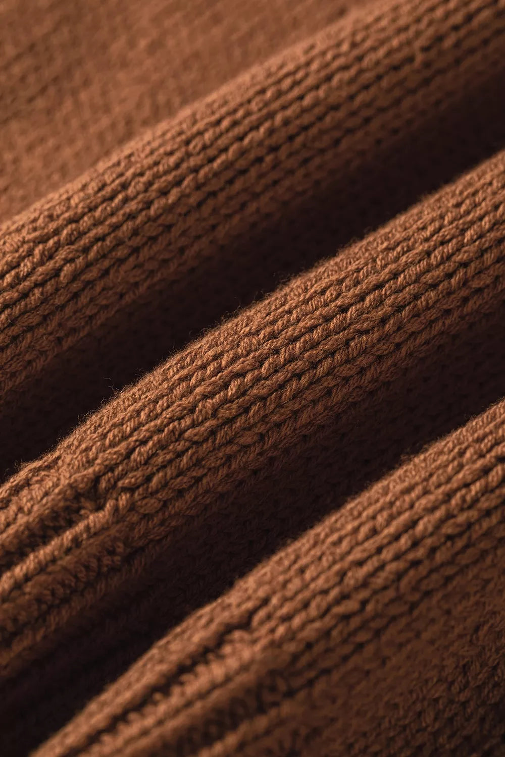 Close up knit view of the Horseshoe Sweater in rust brown knit with a white horseshoe graphic, crew neckline, and ribbed cap sleeves.