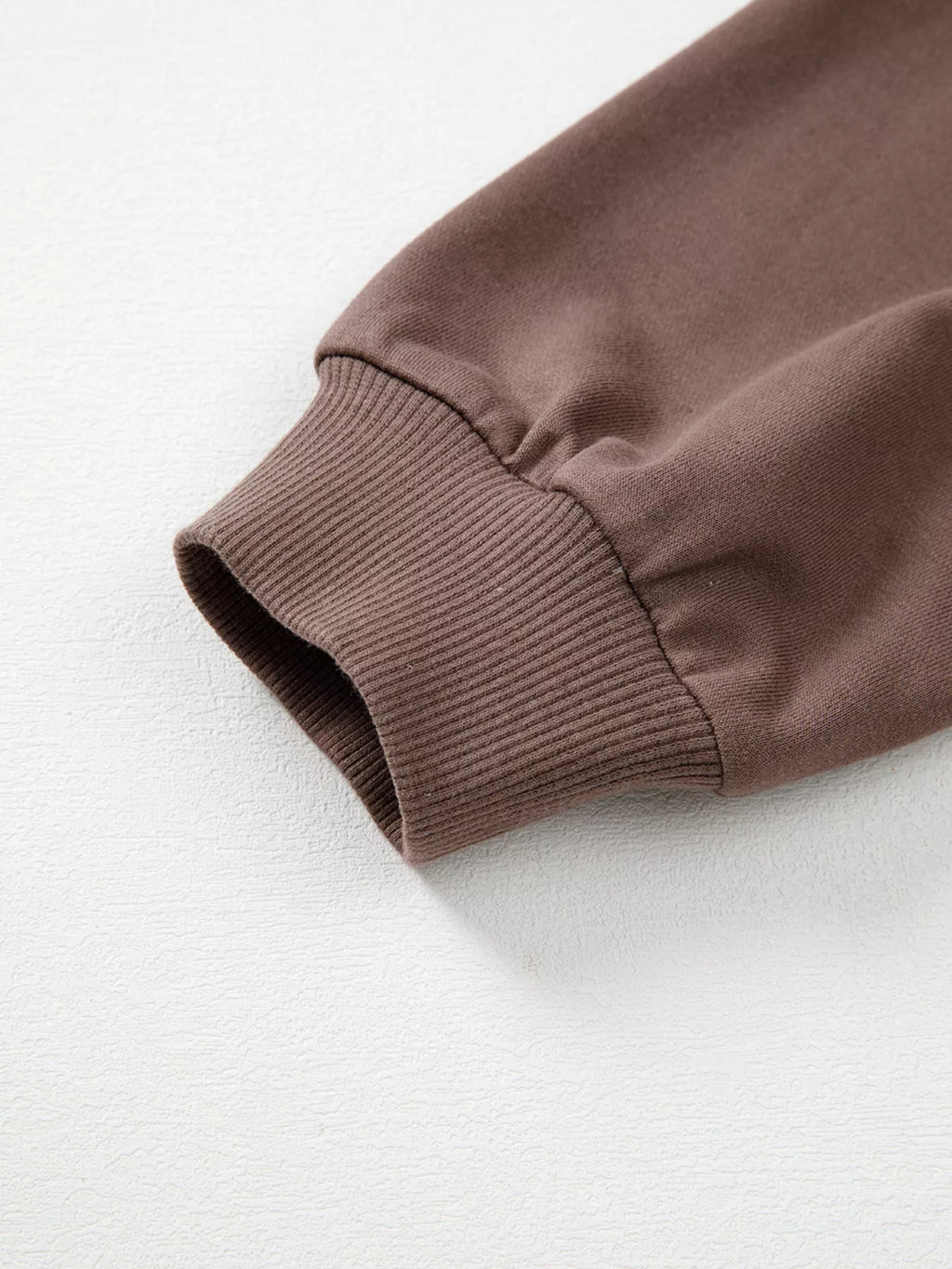 A Change Of Pace Sweatshirt in mocha brown with rust-orange and cream color-block sleeves, shown close up view.