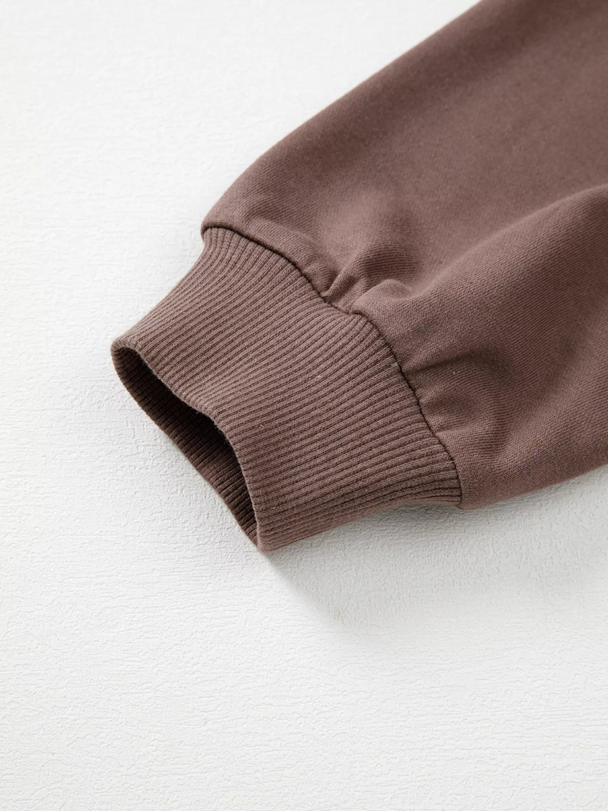 A Change Of Pace Sweatshirt in mocha brown with rust-orange and cream color-block sleeves, shown close up view.