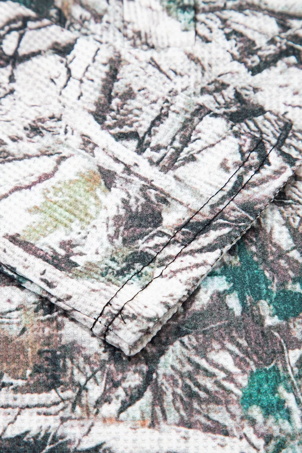The Renegade Short Set in woodland camouflage with a long-sleeve button-front top and drawstring shorts with pockets close up view.