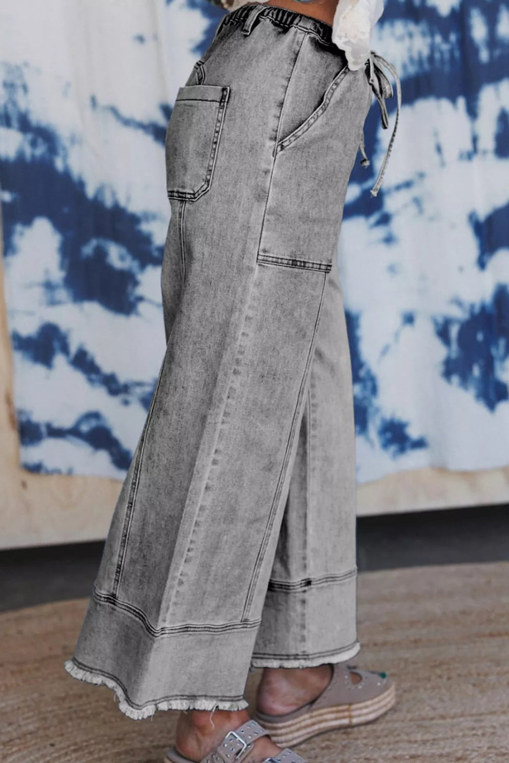 Pants, denim, high-rise, elastic waist, drawstring, belt loops, pocketed front and back, raw/frayed hem, wide leg, slightly stretchy, side view