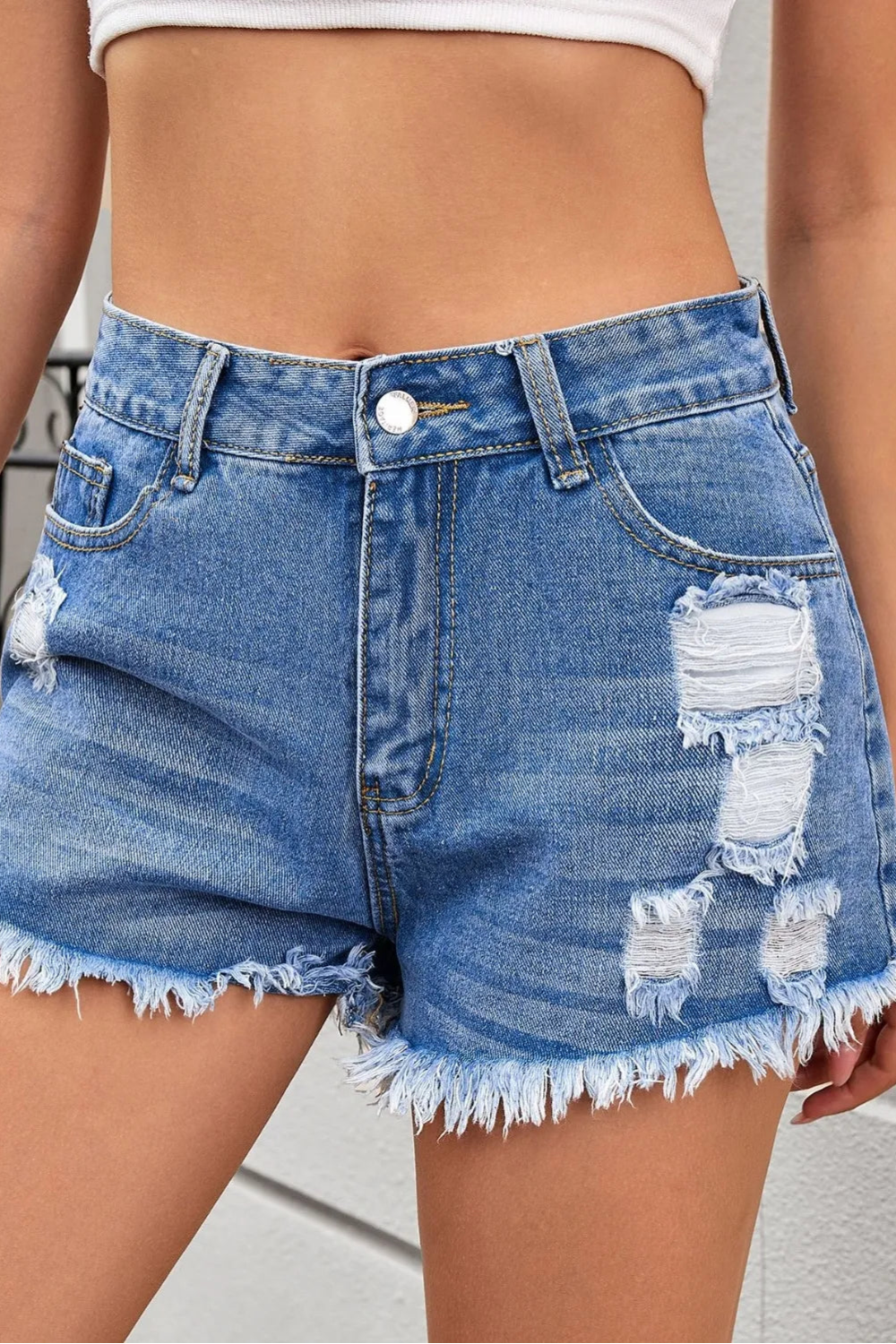 Distressed, Raw hem, High waist, Zipper and button closure, Functioning pockets,  No stretch, Denim shorts Close up view