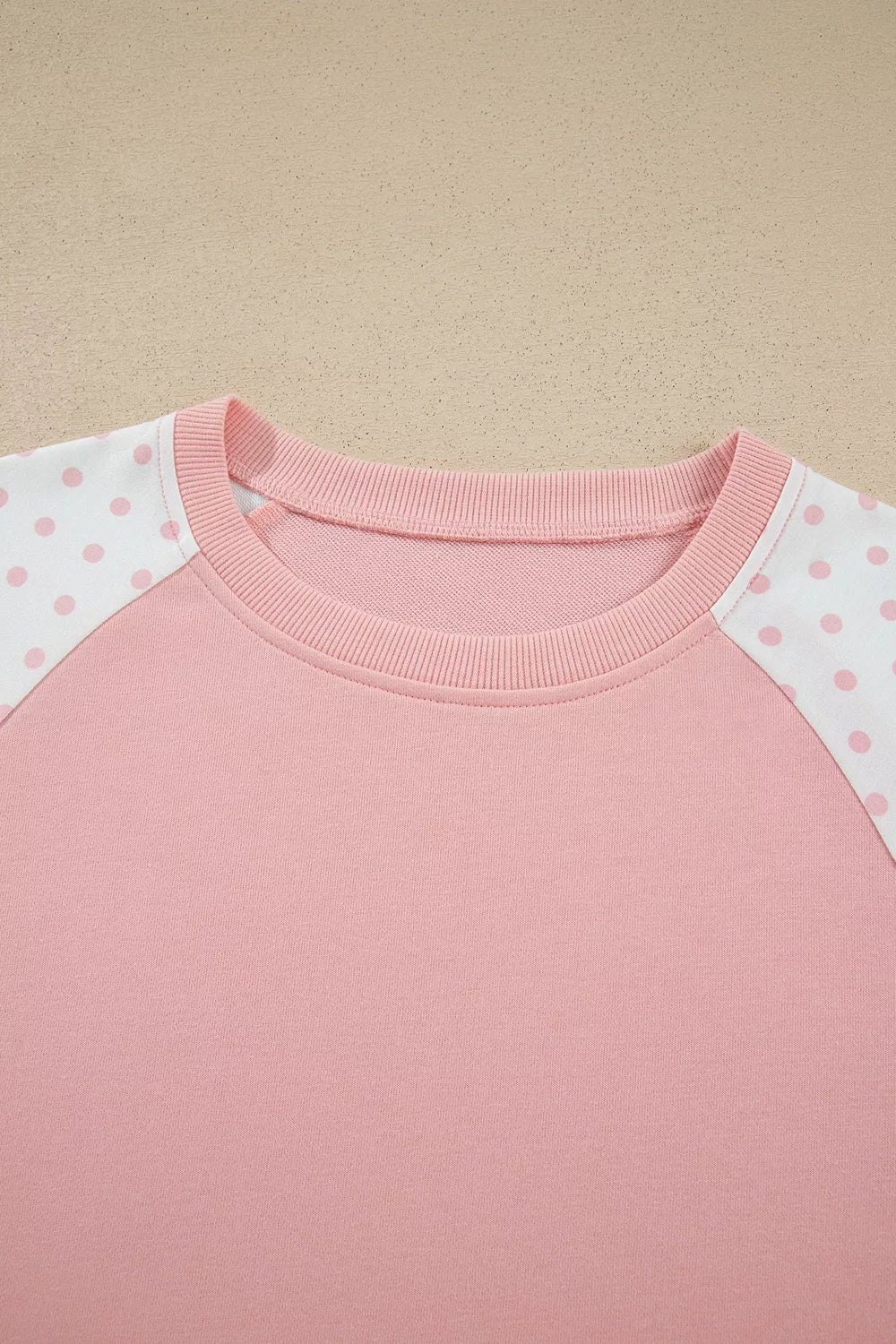 Social Club Pant Set with a light pink cropped sweatshirt, polka-dot shoulder panels, and matching wide-leg drawstring pants close up view.