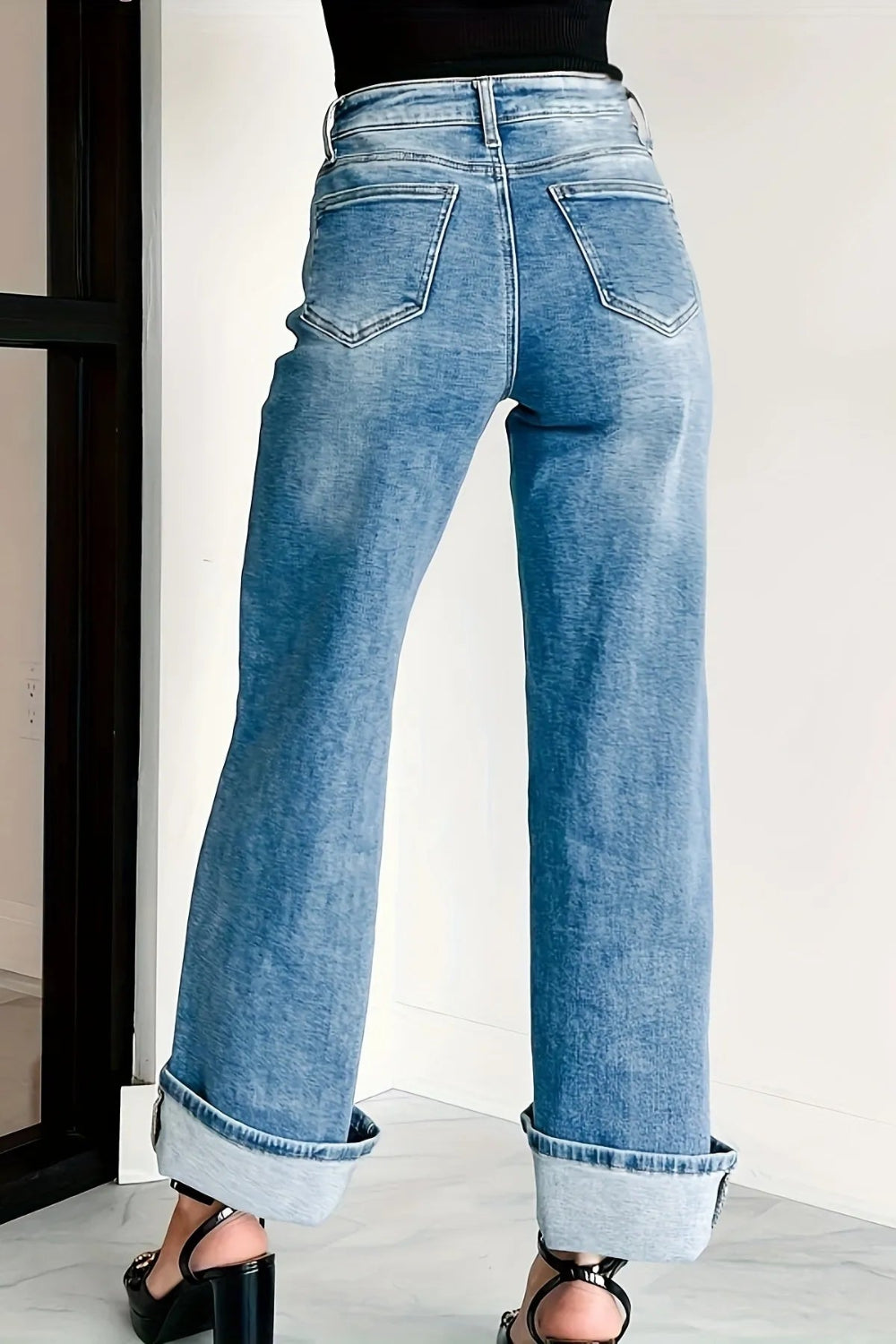 Jeans, high-waist, light wash, wide leg, pocketed, belt loops, button/zipper closure, relaxed fit, slightly stretchy, back view