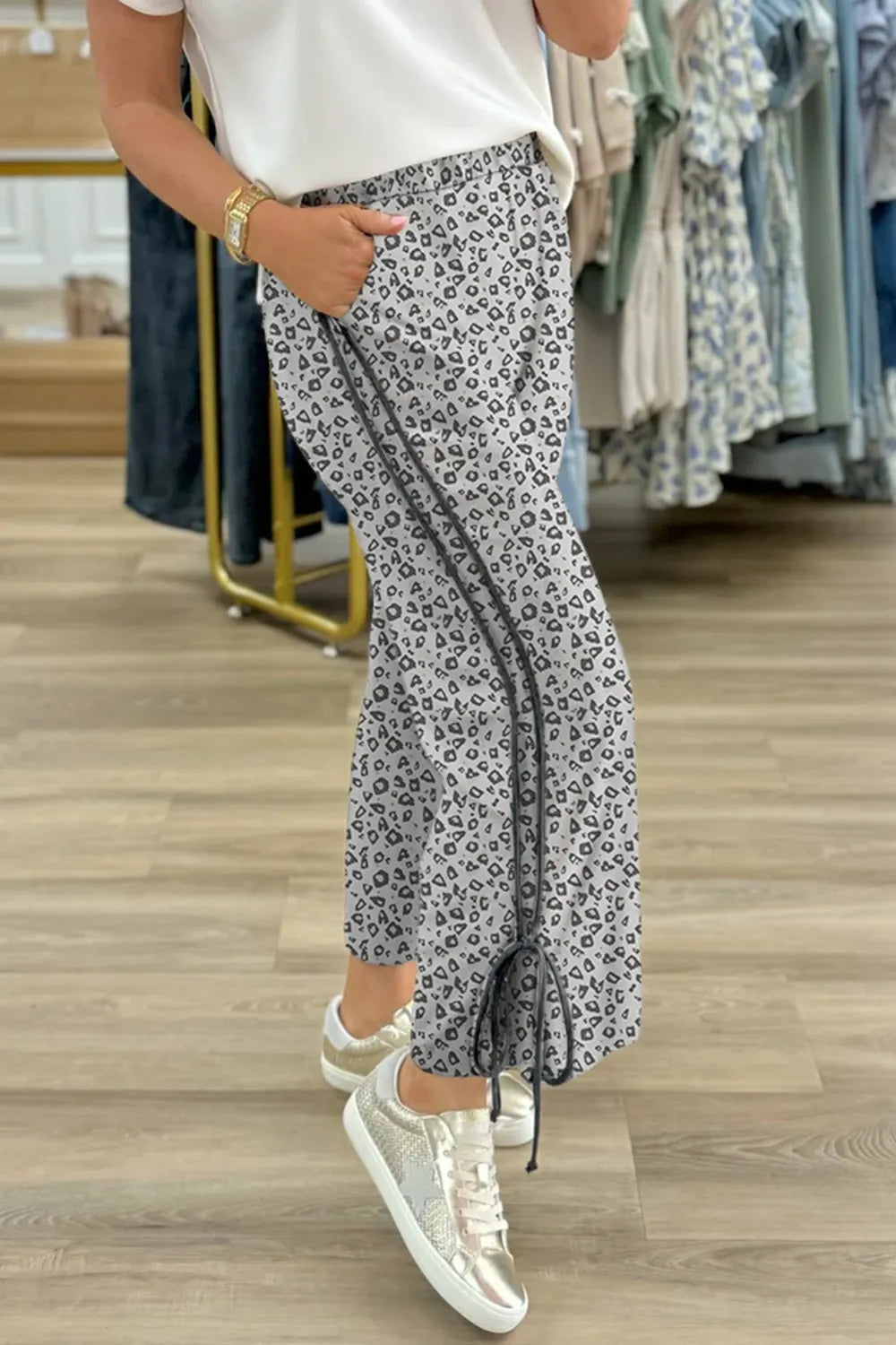 Pants, leopard print, high waist, elastic waistband, no drawstring, piping, side ties, pocketed, gray in color, some stretch side view