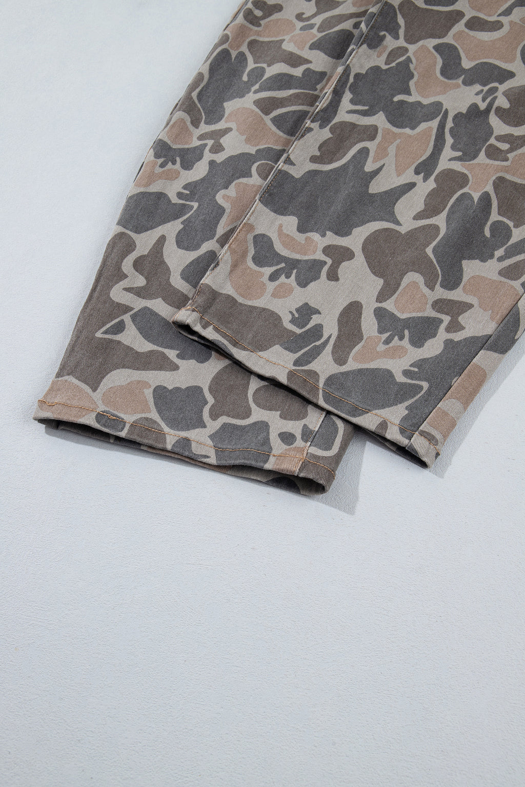 Bottom hem view of the Incognito Jeans in muted taupe and gray camouflage with wide cropped legs and oversized patch pockets.