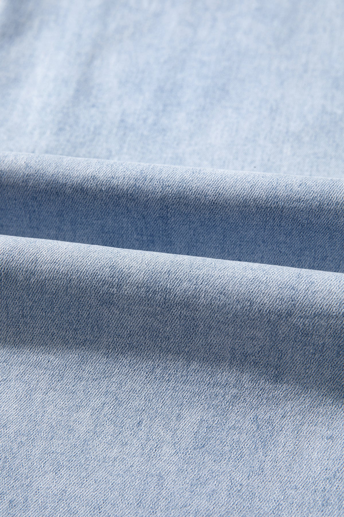 The Second Look Jeans in a light wash with wide cuffed legs, double white lace side panels, and back pockets, shown close up.