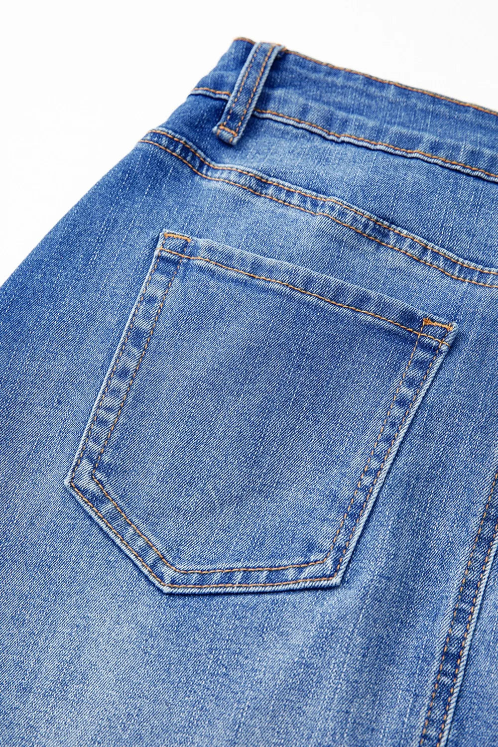 Shop The  Overlap Mini Skirt featuring a medium-blue wash, asymmetrical wrap-style front, curved seam detailing, and flattering A-line fit.