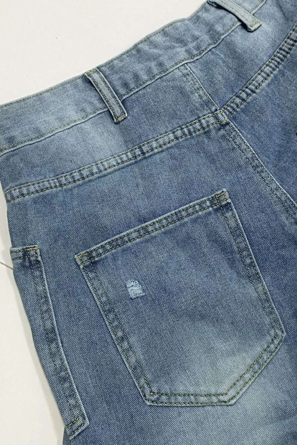 Jeans, high-waist, medium vintage wash, relaxed fit, shirred, distressed, pocketed, button/zipper closure, belt loops, front patch pockets, slightly stretchy, close up view