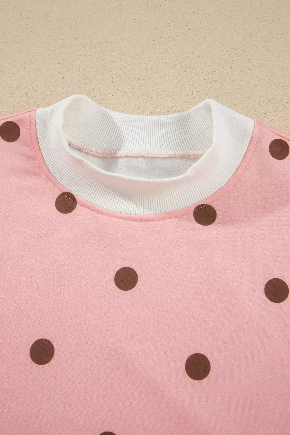 Sweet Pea Short Set in pink with brown polka dots, featuring a long-sleeve top, white mock neck and cuffs, and matching shorts.