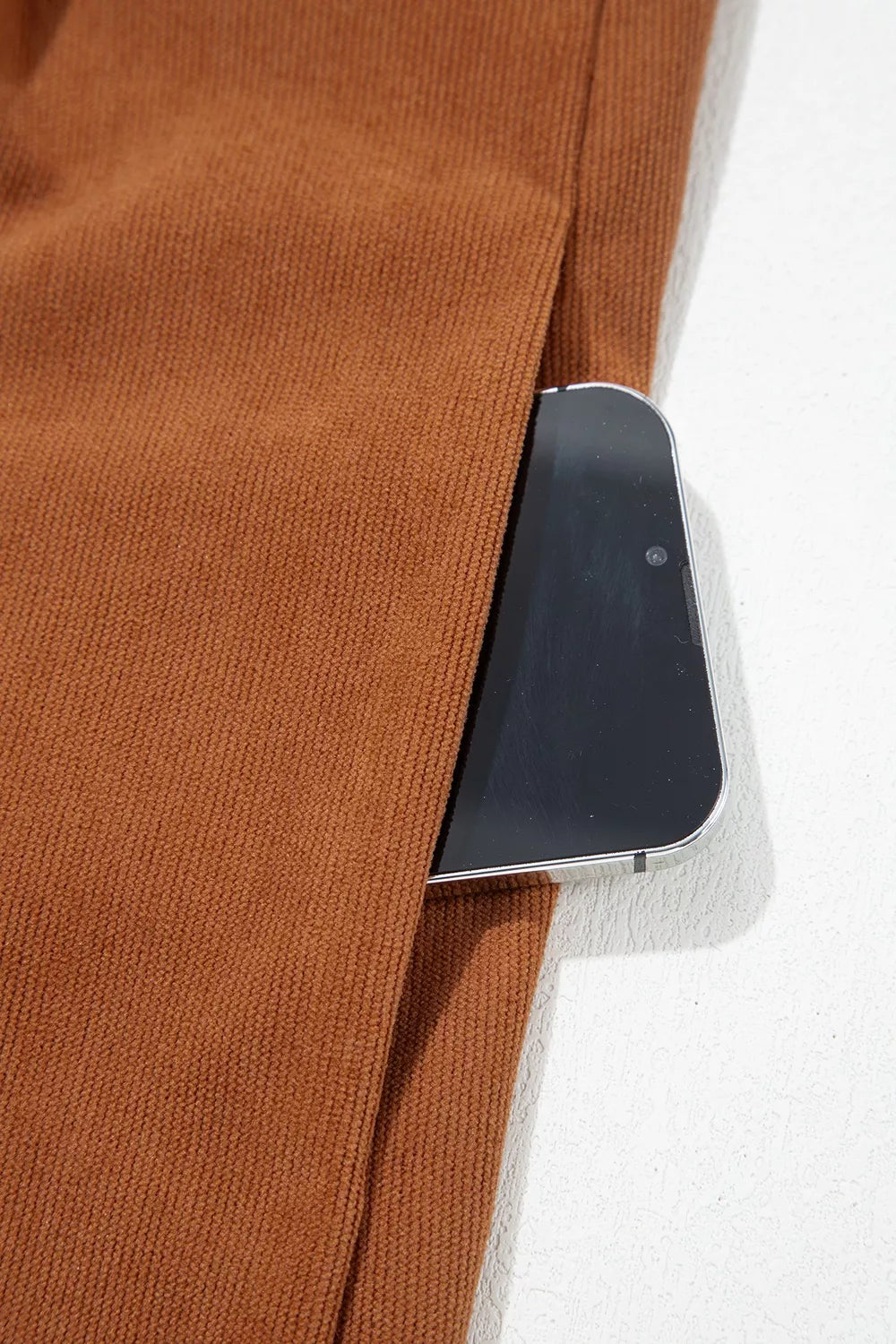 Front view of the As You Were Romper in rust brown corduroy with a tie V-neck, back zipper, pleated details, and side pockets.