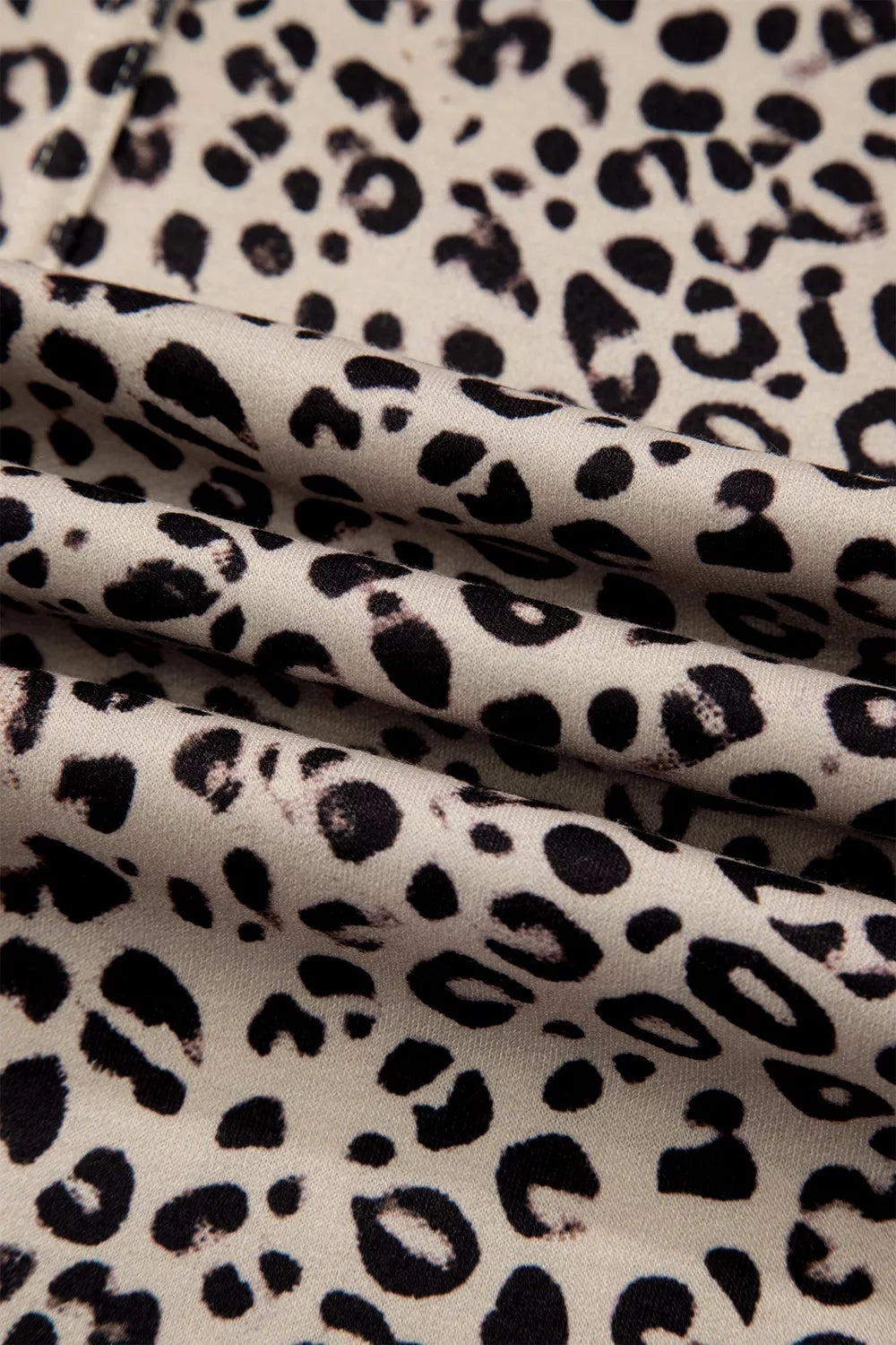 The Ziggy Pants in a beige and black leopard print with wide legs, a drawstring waist, and front patch pockets close up view.