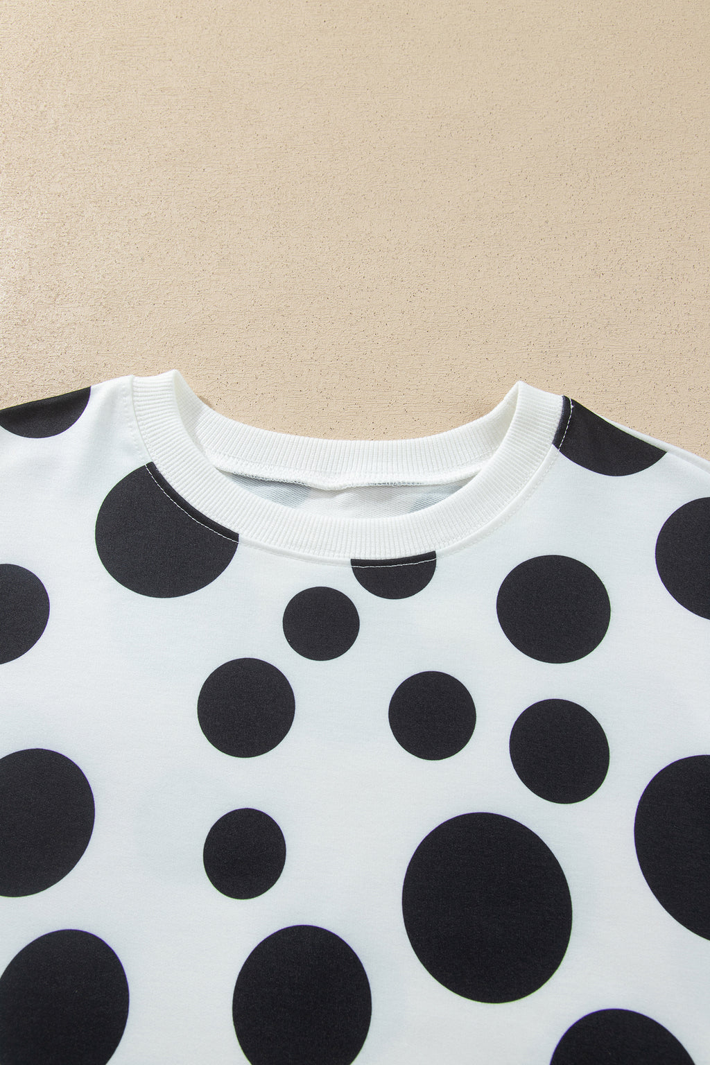Point Taken Pant Set In Black with an ivory-and-black polka-dot sweatshirt and matching wide-leg drawstring pants close up view.