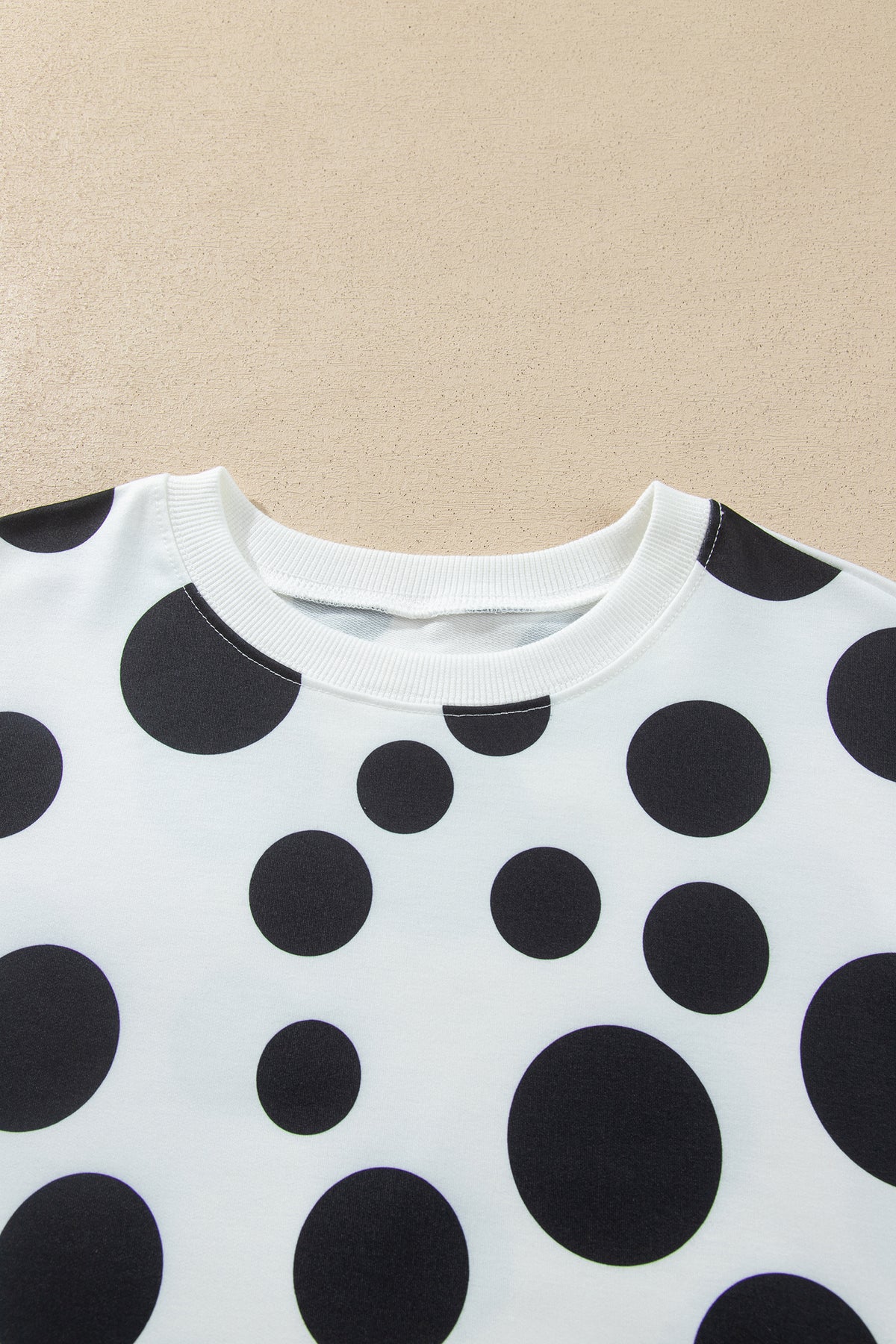 Point Taken Pant Set In Black with an ivory-and-black polka-dot sweatshirt and matching wide-leg drawstring pants close up view.