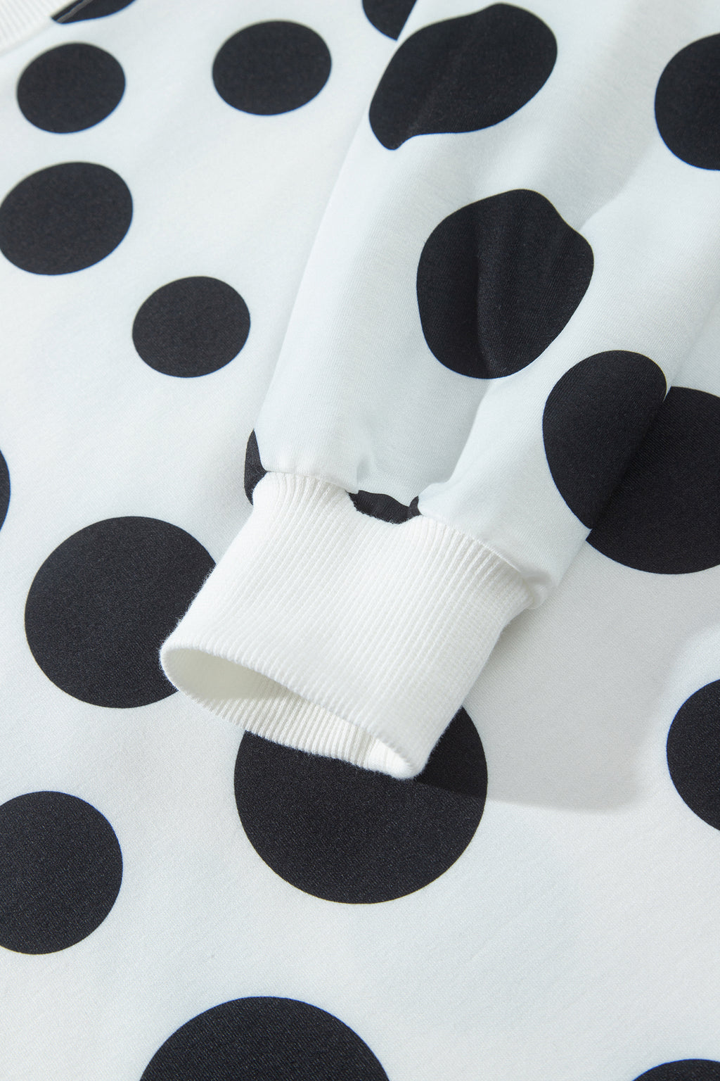 Point Taken Pant Set In Black with an ivory-and-black polka-dot sweatshirt and matching wide-leg drawstring pants close up view.