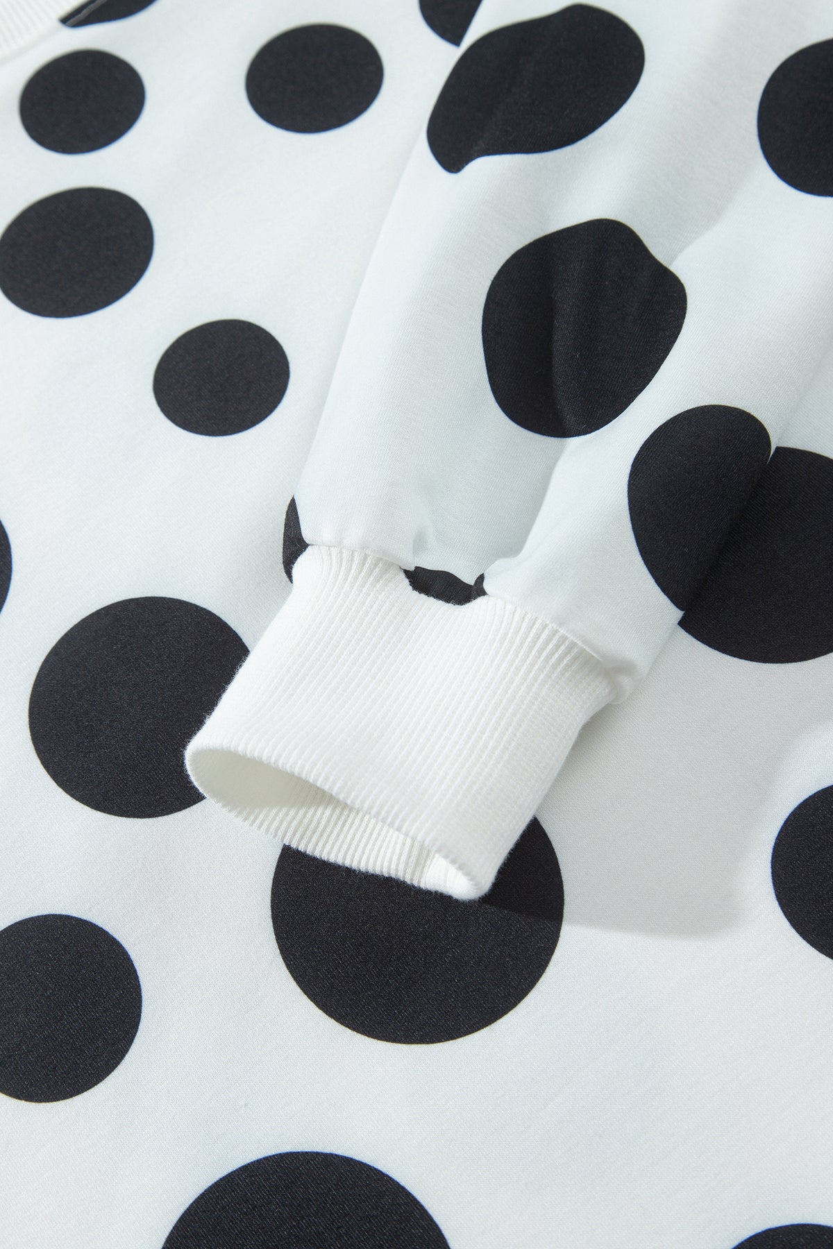 Point Taken Pant Set In Black with an ivory-and-black polka-dot sweatshirt and matching wide-leg drawstring pants close up view.