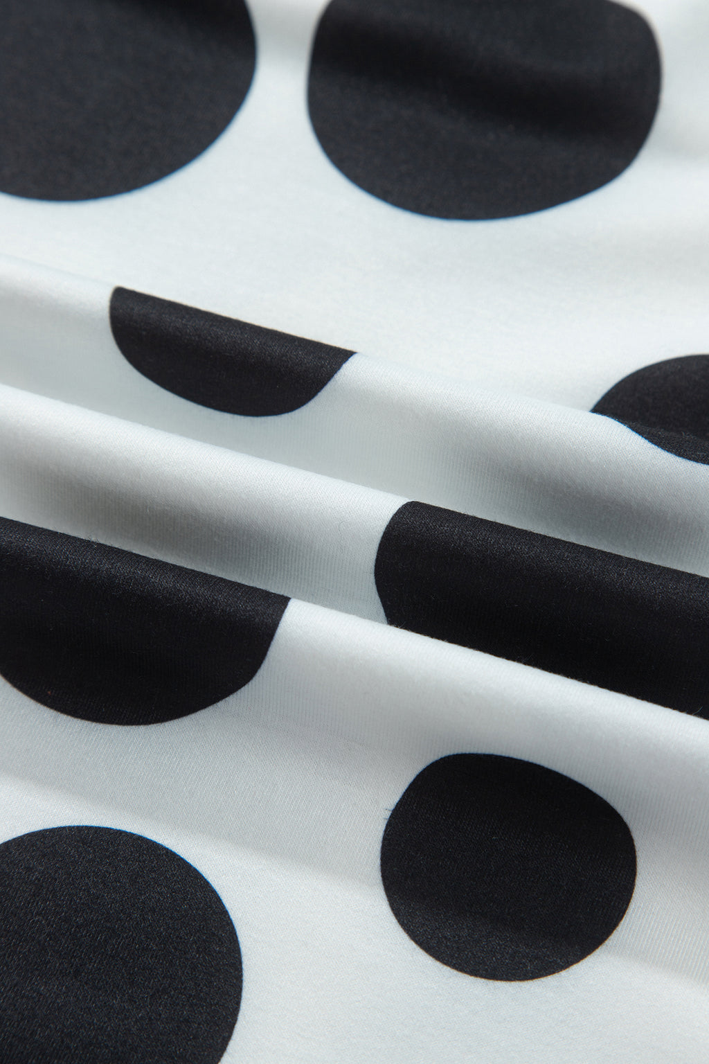 Point Taken Pant Set In Black with an ivory-and-black polka-dot sweatshirt and matching wide-leg drawstring pants close up view.
