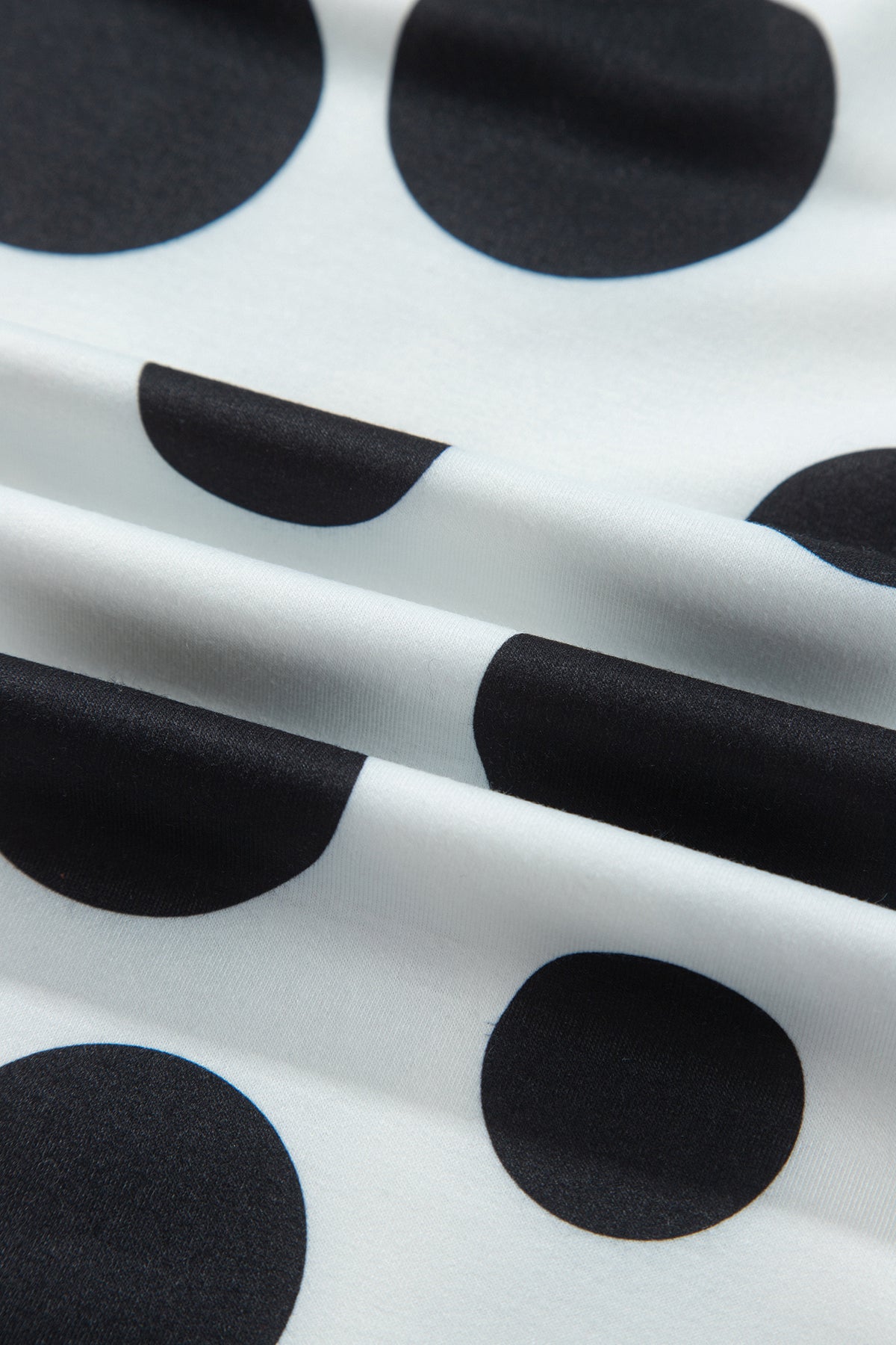 Point Taken Pant Set In Black with an ivory-and-black polka-dot sweatshirt and matching wide-leg drawstring pants close up view.