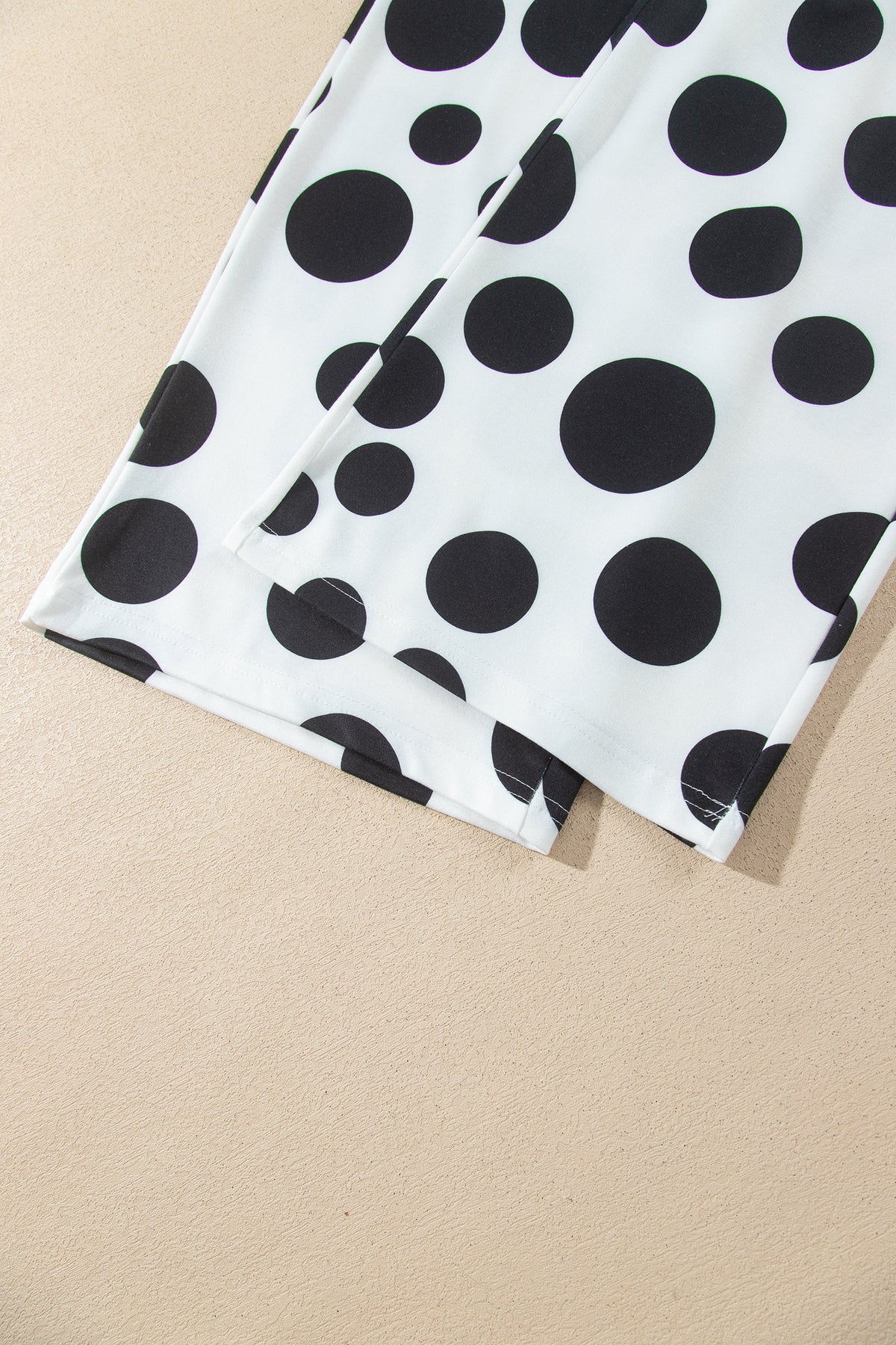 Point Taken Pant Set In Black with an ivory-and-black polka-dot sweatshirt and matching wide-leg drawstring pants close up view.