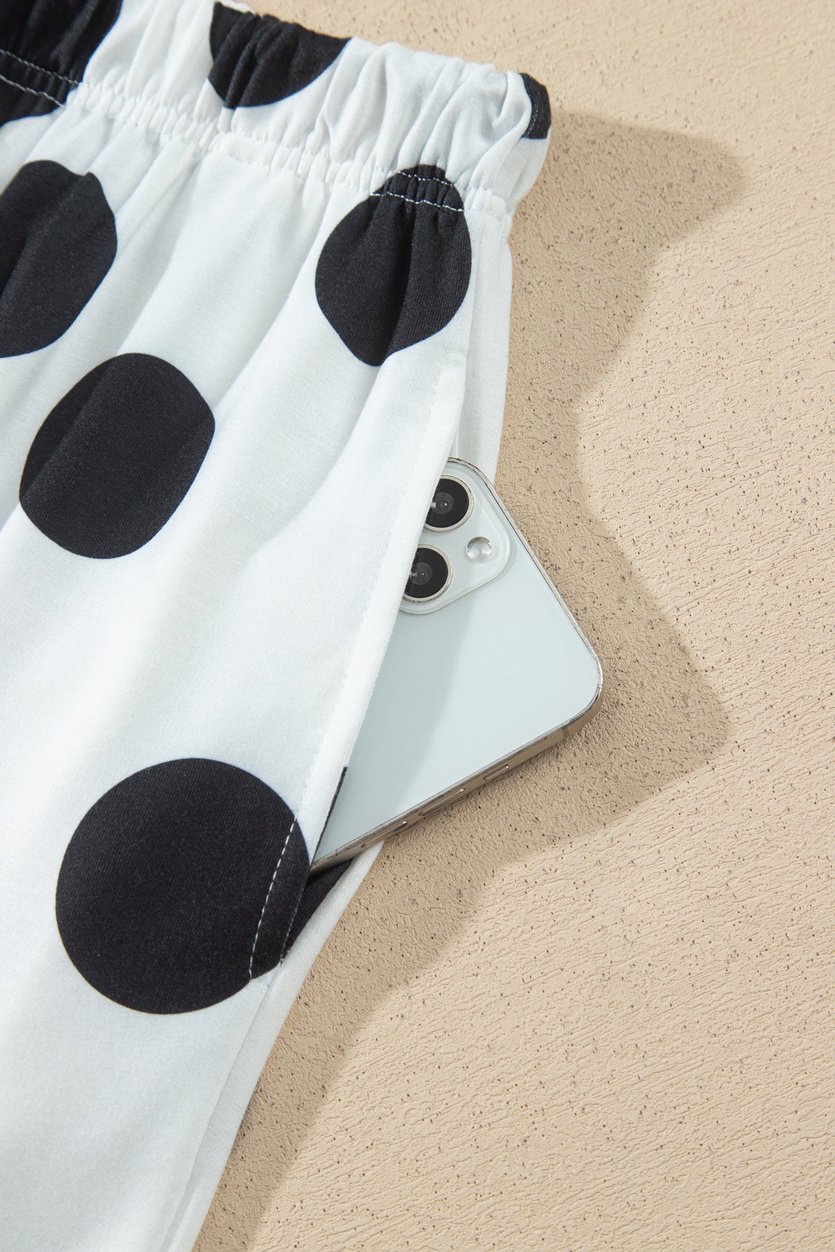 Point Taken Pant Set In Black with an ivory-and-black polka-dot sweatshirt and matching wide-leg drawstring pants close up view.