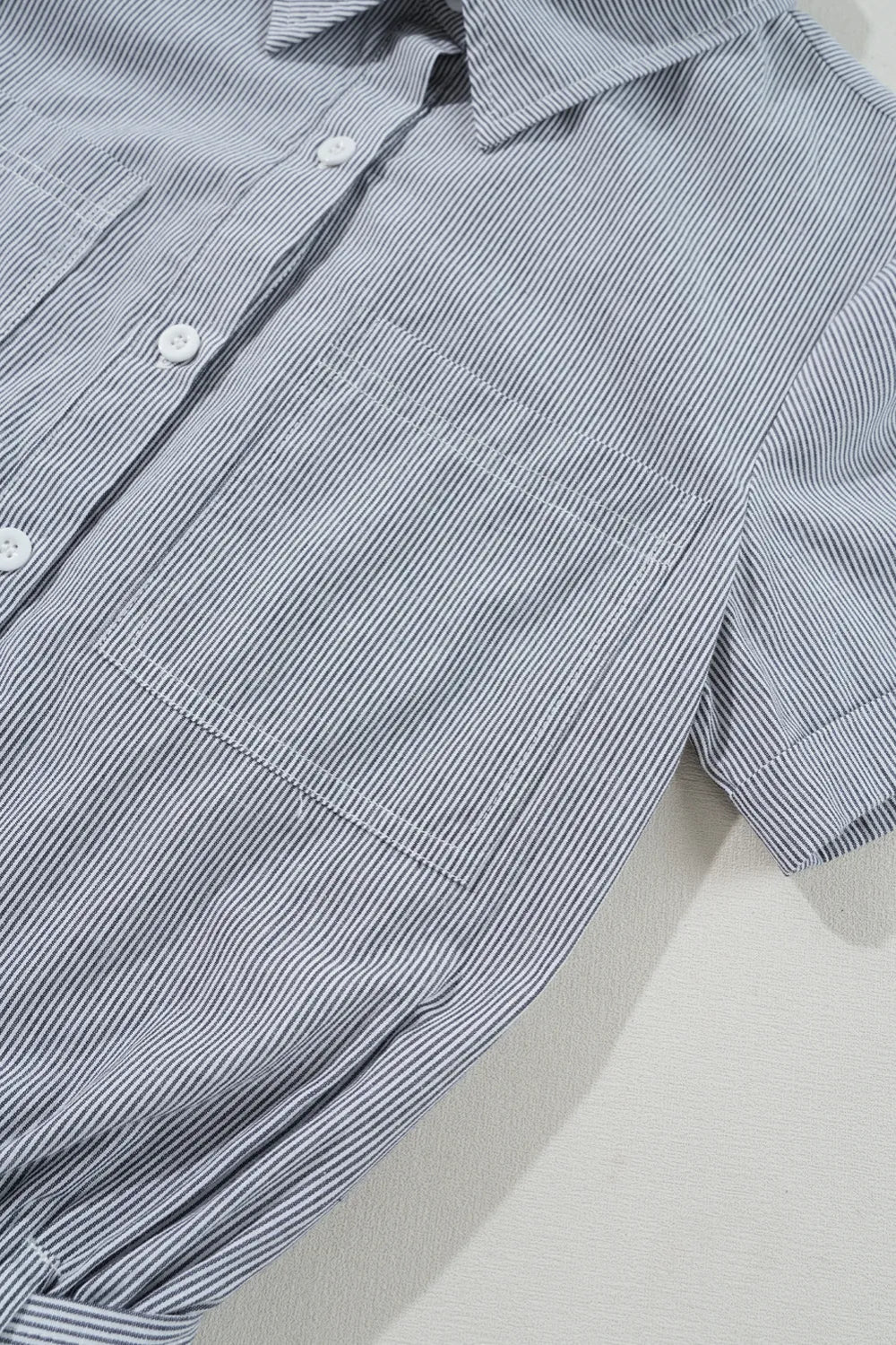 Romper, collared, short sleeve, cuff sleeve, buttoned, belted, opaque, pleated, elastic waist, no stretch close up view
