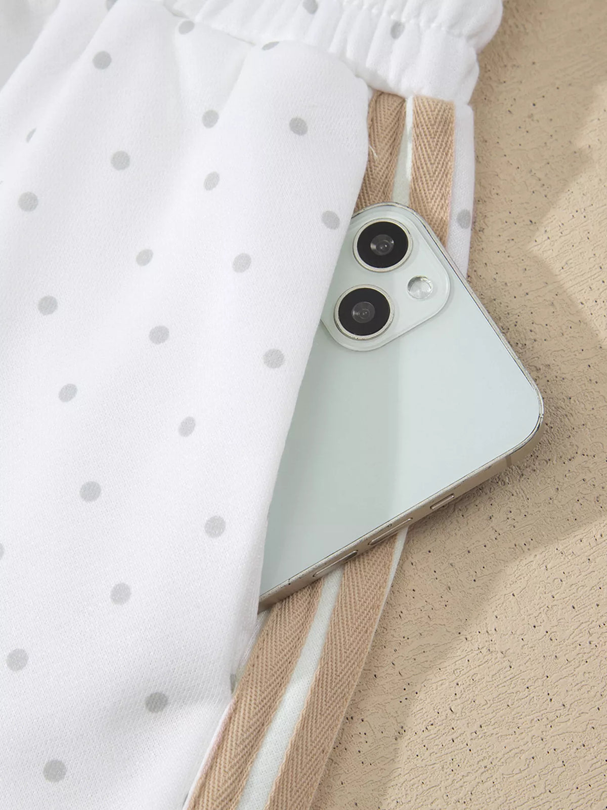 Cozy Dream Short Set in ivory with gray polka dots, a long-sleeve striped top, and matching ruffle-trim shorts close up view.