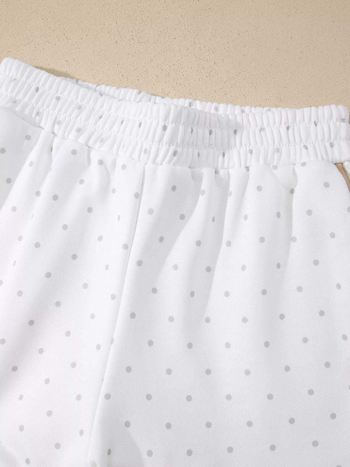 Cozy Dream Short Set in ivory with gray polka dots, a long-sleeve striped top, and matching ruffle-trim shorts close up view.
