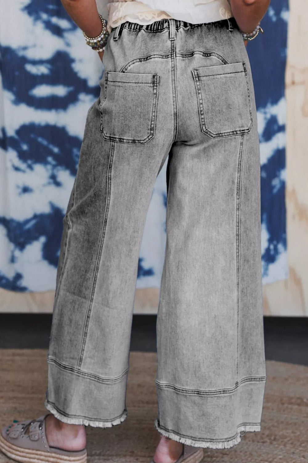 Pants, denim, high-rise, elastic waist, drawstring, belt loops, pocketed front and back, raw/frayed hem, wide leg, slightly stretchy, back view