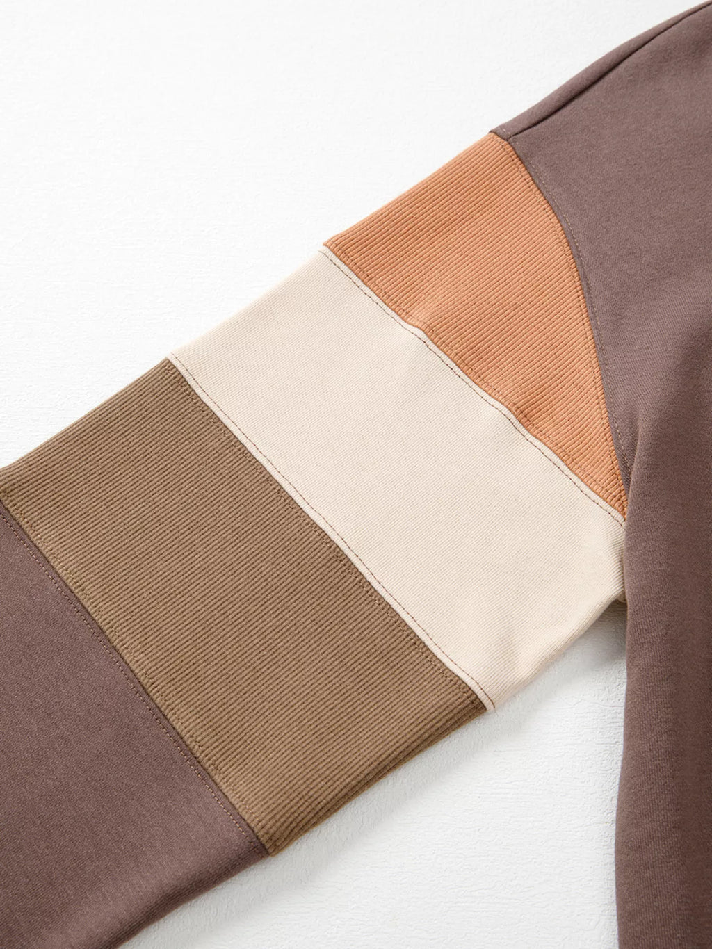 A Change Of Pace Sweatshirt in mocha brown with rust-orange and cream color-block sleeves, shown close up view.